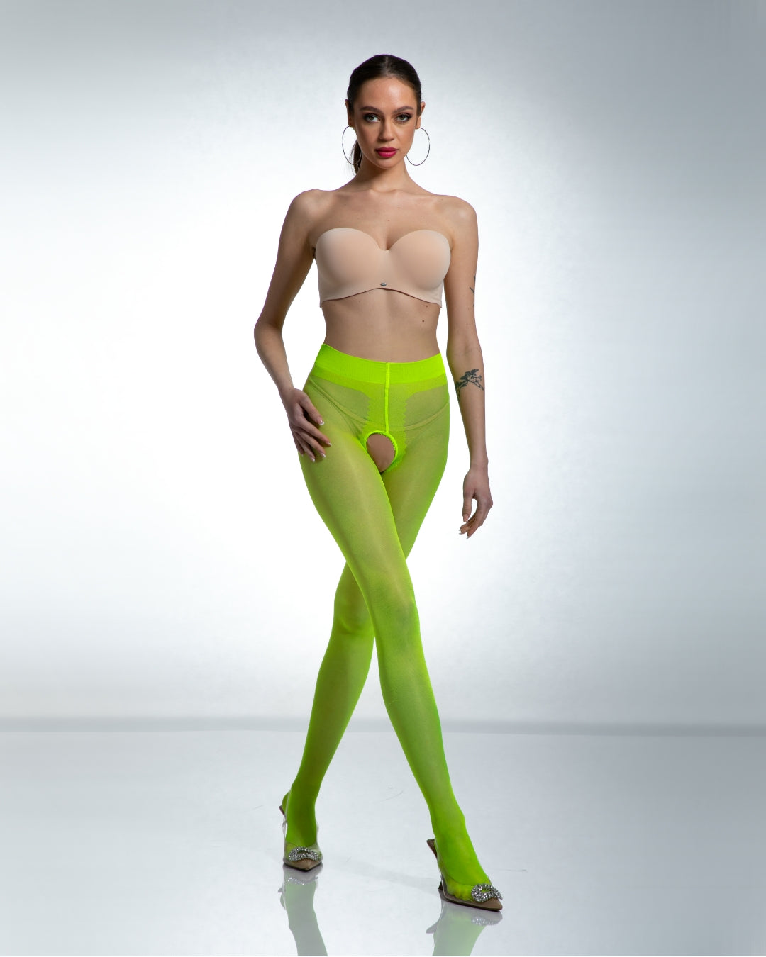 modelka prezentująca błyszczące neonowe damskie otwarte rajstopy z wycięciem w kroku i dziurką