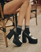 Modelka prezentująca czarne damskie skarpetki rajstopowe do szpilek ozdobione wzorem w kropki Gabriella Dina